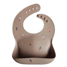 Load image into Gallery viewer, Mushie Silicone Baby Bib | Rocket