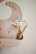 Load image into Gallery viewer, Mushie Silicone Baby Bib | Rocket